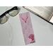 this cowgirl bookmark is on white table with an open book top right & fairy lights & glasses on the left side