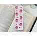 this pink western bookmark is on a white table