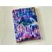 this castle book sleeve is purple with castles and waterfall all over the book holder.