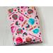 this candy book sleeve has a pink background with colorful cotton candy, lollipops, cupcakes all different candies