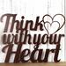 Close up of Think with your Heart metal sign, with two hearts, in copper vein powder coat.