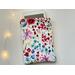 a ereader is peeking out of the watercolor kindle sleeve