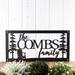 Rectangular family name metal sign with Adirondack chair and fir pine trees, in matte black powder coat.