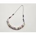 necklace with 1/2" in diameter white and purple shell button style beads, smaller faceted charoite gemstones, and a stainless steel chain 