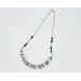 necklace with 1/2" in diameter white and purple shell button style beads, smaller faceted charoite gemstones, and a stainless steel chain 