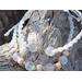 close up 2 piece white frosted beaded wristwear displayed outside on tree trunk