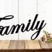 Close up of family script metal sign, in matte black powder coat.