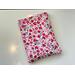 this floral book sleeve has a white background with tiny red and pink flowers and hearts all over it
