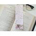 this puppy bookmark has a light pink background  with three dogs and pink flowers at the bottom. there are dog bones, and red and pink hearts falling.
