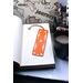 Front of bookmark with orange background, hand painted paw prints and various dot art designs in white. Jute rope tassel.