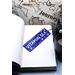 Front of bookmark royal blue background, handwritten lettering in white, starfish and turtles.  Jute rope for tassel.
