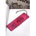 Front of bookmark, hot pink background, black handwritten lettering, black and white dot art designs around edge.  Jute rope tassel.