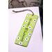 Front of bookmark, lime green background, handwritten black lettering, white and black dot art flowers, jute rope tassel.