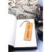 Front of bookmark, orange background, handwritten black lettering, white and black dot art flowers, jute rope tassel.