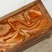 Tea chest with  fluid acrylics in orange, brown and gold.