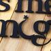 Close up of lettering on our Always Kiss Me Goodnight metal wall decor, in matte black powder coat.