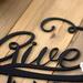 Close up of matte black powder coat on our Give Thanks metal wall art.