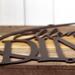 Close up of copper vein powder coat on the oval metal family name sign.