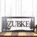 Rectangular metal family name sign, with a doe deer silhouette, in silver vein powder coat.
