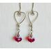 Silver wire shaped into hearts adorned with red crystal Swarovski beads. Great for Valentine's Day or any day.