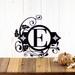 Metal monogram sign with fleur de lis and vines, in matte black powder coat. 