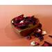 Decorative apple cinnamon potpourri in a heart-shaped wooden bowl, with a soft, ombre styled background in light to dark orange.