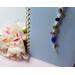Multi color glass and clear faceted crystal beaded bookmark with a silver tone dragonfly charm at the end. Measures 12" in length.