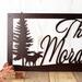 Close up of moose and pine trees on our personalized family last name metal plaque, in copper vein powder coat.
