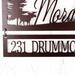 Close up of metal address sign on our family name sign, with a moose silhouette, in copper vein powder coat.