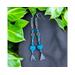 Pretty handmade western dangle earrings. Three inches long with saddle stirrup charms and turquoise blue stones.