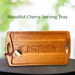 Beautiful handcrafted cherry serving tray with custom engraving, featuring smooth handles and a rich wood finish, perfect for home decor.