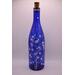 One side of bottle with fairy lights on in low light