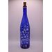 View of alternate side of bottle with fairy lights on in low light.
