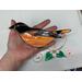 Baltimore Oriole suncatcher being held for size reference.
