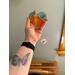 Heart-Sun ornament being held for size reference.