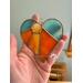 Heart-Sun ornament being held for size reference.