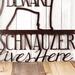 Close up of A Schnauzer Lives Here metal sign, in copper vein powder coat.
