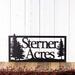 Rectangular metal house name sign with pine trees, in matte black powder coat.