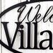 Close up of oval welcome to home name metal sign, in matte black powder coat.