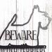 Close up of Scottish Terrier silhouette, with Beware, in silver vein powder coat.