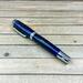 resin cast rollerball pen made with pinecone and blue resin