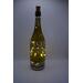 Full view of bottle with dot art designs and darker lighting.