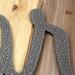 Close up of script lettering on our personalized metal name sign, in silver vein powder coat.