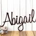 Personalized metal name sign with cursive lettering, in copper vein powder coat.