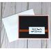 A Halloween card kit with black embossed cardstock, orange cardstock mat, 'Happy Halloween" sentiments and orange ribbons.