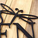 Close up of matte black powder coat on our metal garden name sign with a dragonfly.
