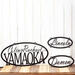 Custom oval metal sign with first and last name, and two child name signs, in matte black powder coat.