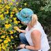 Woman wearing bucket hat with ponytail through the opeing.