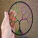 wire tree front view standing up in bed of polished stone.