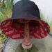 Front view of bucket hat on stand. Hat is reversed to show the black side, with the red and gold SF 49ers logos fabric underneath.